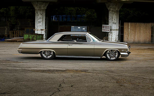 A sleek Chevrolet Impala muscle car with custom wheels, parked in an urban setting, shown in high-definition as a hot rod vehicle HD desktop wallpaper.
