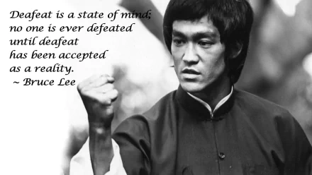 HD desktop wallpaper featuring Bruce Lee in martial arts attire, with his famous quote: Defeat is a state of mind; no one is ever defeated until defeat has been accepted as a reality.