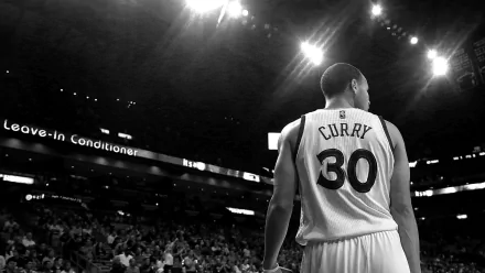 HD wallpaper featuring a black and white image of a basketball player with the name Curry on his jersey, standing on a court facing a crowd.