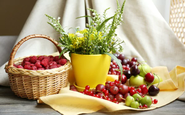 5K Ultra HD desktop wallpaper: still life of a wicker basket of raspberries, scattered cherries and gooseberries, and a yellow pot of green foliage on a draped cloth.