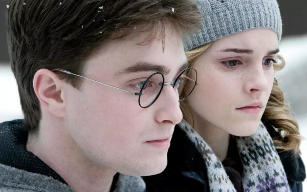 HD wallpaper featuring Harry Potter (Daniel Radcliffe) and Hermione Granger (Emma Watson) in a snowy scene from Harry Potter and the Half-Blood Prince.