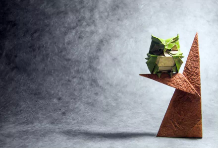 HD desktop wallpaper featuring a man-made origami owl perched on a geometric shape against a textured grey background.