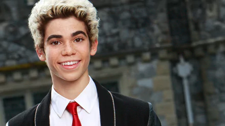 HD desktop wallpaper featuring a person with a bright smile, wearing a black and red outfit, with a historical building in the background.