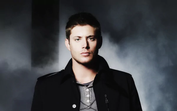 HD desktop wallpaper featuring a man in a black coat against a moody, smoke-filled background.
