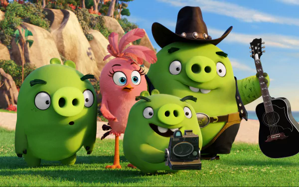 HD desktop wallpaper from The Angry Birds Movie showing three green pigs and a pink bird in a grassy outdoor setting. One pig is holding a guitar, and another has a camera.