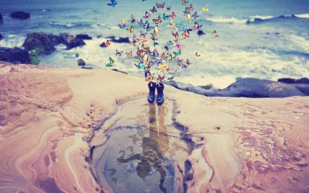 HD wallpaper features a child’s boots on a sandy shore with vibrant butterflies emerging from them, reflected in a puddle. The ocean waves crash in the background, showcasing beautiful photo manipulation.