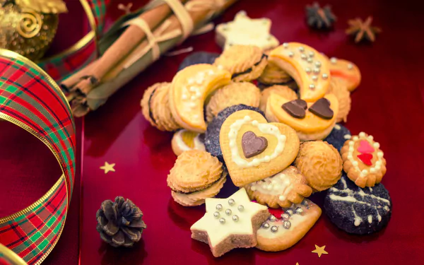 5K Ultra HD PC desktop wallpaper and background: assortment of cinnamon cookies and festive food—heart, star and jam cookies with cinnamon sticks, ribbon and star confetti on red.