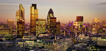 HD desktop wallpaper of a London cityscape, showcasing an array of skyscrapers and buildings at dusk, including the iconic Gherkin. The vibrant cityscape highlights the architectural beauty of the United Kingdom's capital.