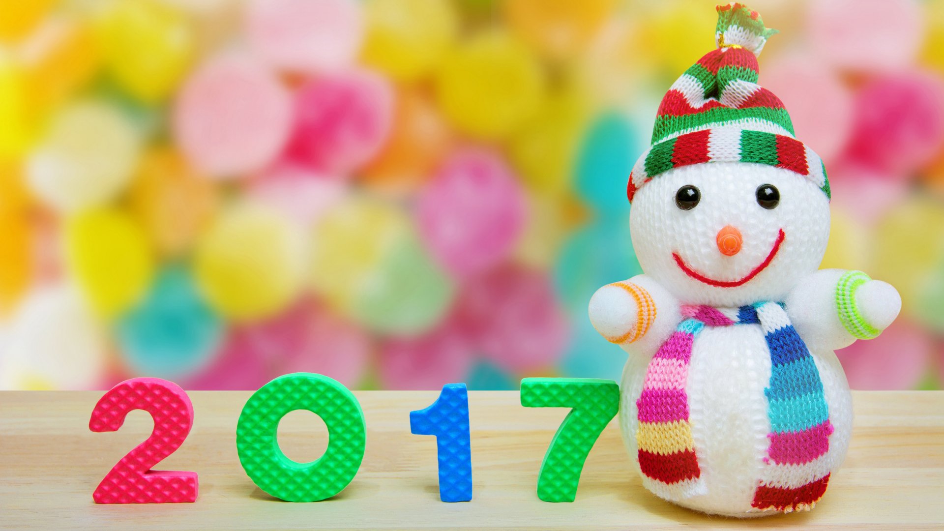 Colorful 2017 numbers with a cheerful snowman wearing a striped hat and scarf against a vibrant bokeh background, celebrating New Year 2017 in 4K Ultra HD.