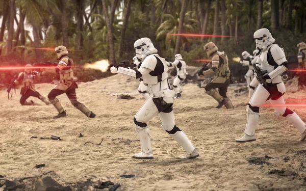 A HD desktop wallpaper featuring an intense battle scene with stormtroopers from Rogue One: A Star Wars Story on a sandy, tropical battlefield, with blaster fire illuminating the action.