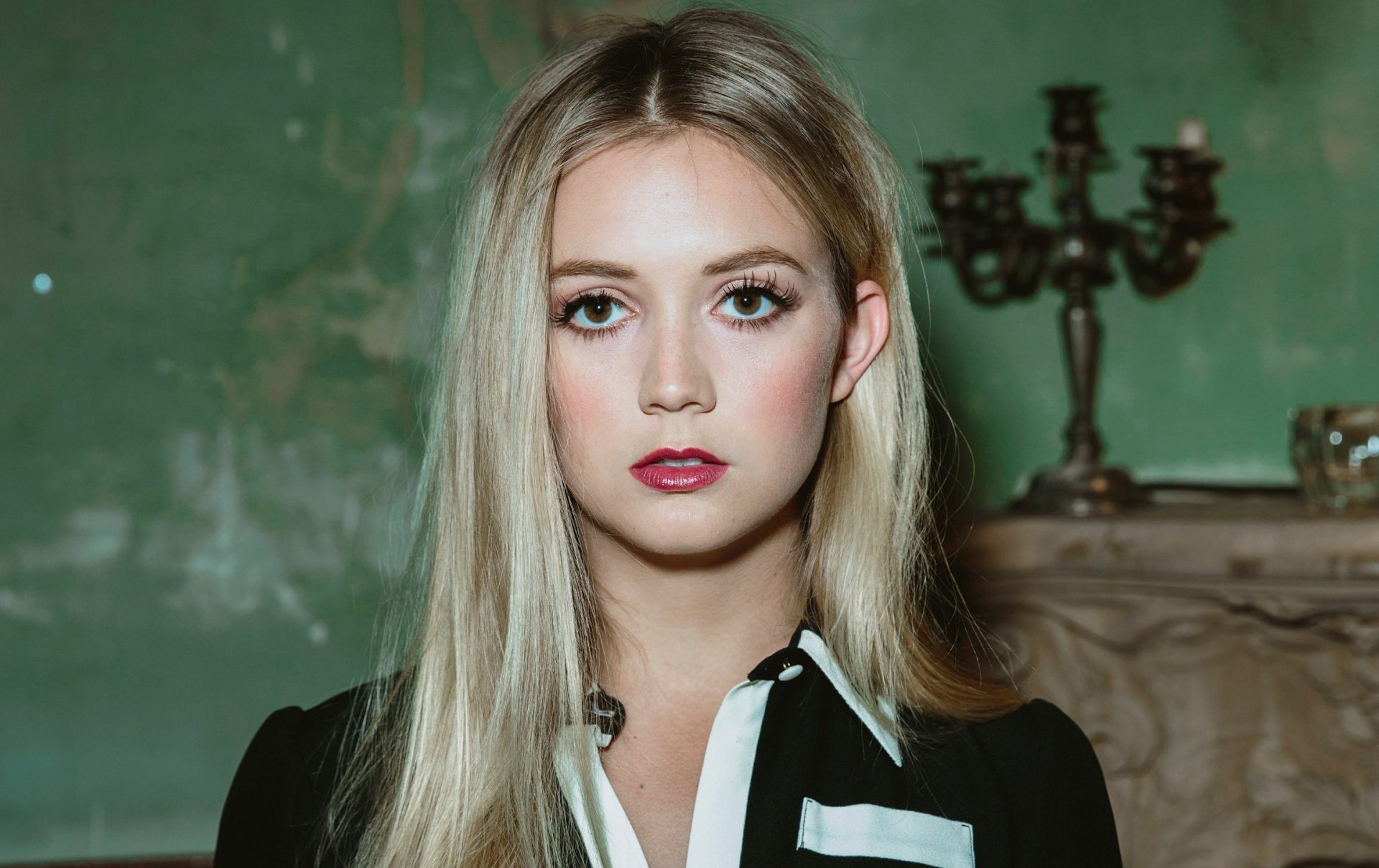 HD desktop wallpaper featuring a close-up portrait of blonde actress and model Billie Lourd with a vintage green background and elegant decor.