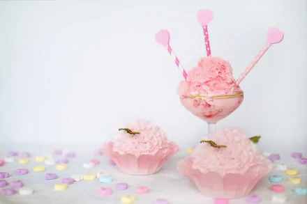 HD desktop wallpaper featuring pink-themed sweets: a bowl of ice cream with heart-topped sticks and two cupcakes, surrounded by colorful candy.