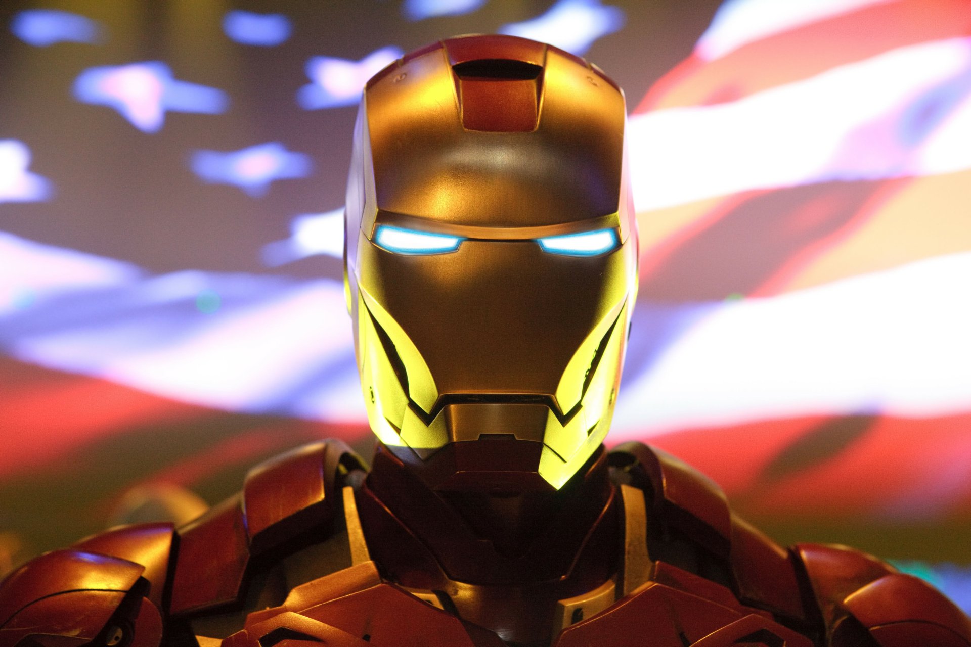 HD desktop wallpaper featuring Iron Man with an illuminated American flag background, showcasing the iconic superhero armor.