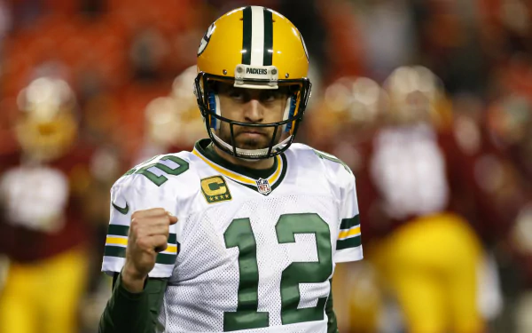 HD wallpaper of a football player in a green and yellow jersey with the number 12, set against a blurred stadium background.