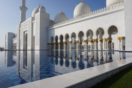 A stunning HD wallpaper of a marble mosque in Abu Dhabi, United Arab Emirates, showcasing domes and arches beautifully reflecting in a serene pool.