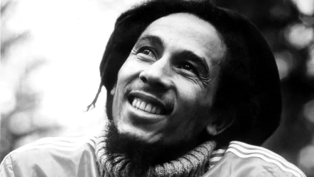 Black and white HD desktop wallpaper featuring a smiling Bob Marley, influential in ska and reggae music, wearing a knitted scarf and a jacket.