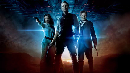 HD PC desktop wallpaper of three lead characters from the movie Cowboys & Aliens — two gunslingers and a woman stand backlit beneath a hovering alien ship.