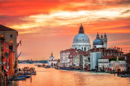 HD desktop wallpaper showing a sunset over Venice's Grand Canal with historic buildings and a prominent dome, capturing the city's enchanting beauty.