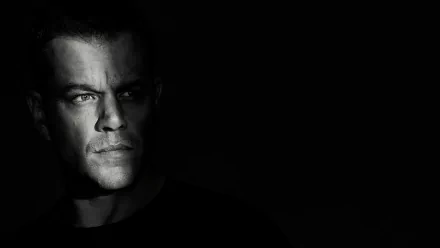 HD wallpaper of Jason Bourne movie, featuring a close-up of a man's face in dramatic lighting, against a dark background.