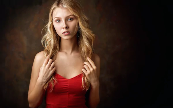 Blonde woman model Alice Tarasenko in a red dress poses against a dark, blurred background in this HD desktop wallpaper and background image.
