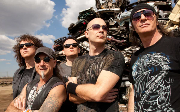 HD PC desktop wallpaper of a five-member heavy metal band in sunglasses and black shirts, posing confidently before a scrapyard backdrop — bold rock music group portrait.