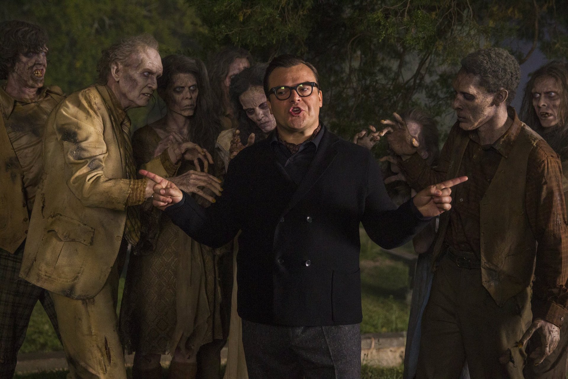 Jack Black surrounded by zombies in a dark outdoor scene from the Goosebumps movie, featured as an HD PC desktop wallpaper and background.