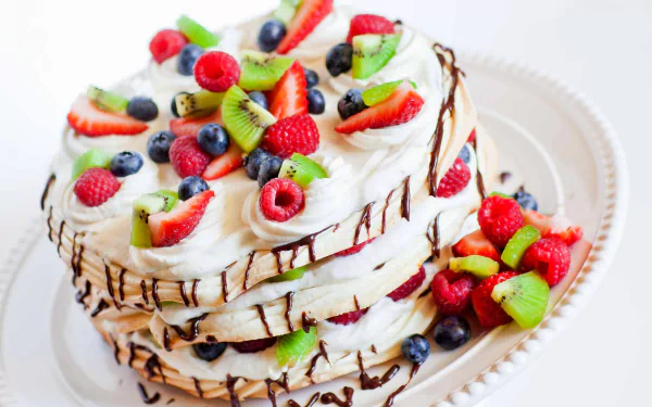 5K Ultra HD PC desktop wallpaper and background of a layered cream pastry cake topped with strawberries, raspberries, blueberries and kiwi slices, finished with chocolate drizzle.