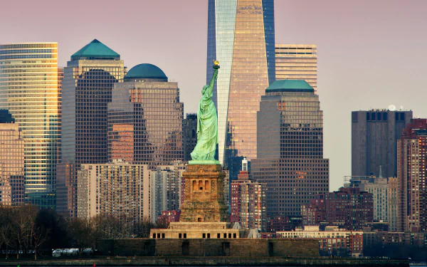 HD PC desktop wallpaper of the Statue of Liberty in New York, USA, standing before a man-made skyline of skyscrapers and buildings in Lower Manhattan.
