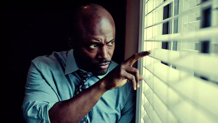 HD PC desktop wallpaper: intense scene from TV show Murder in the First — a man in shirt and tie peers through blinds, tense and alert.