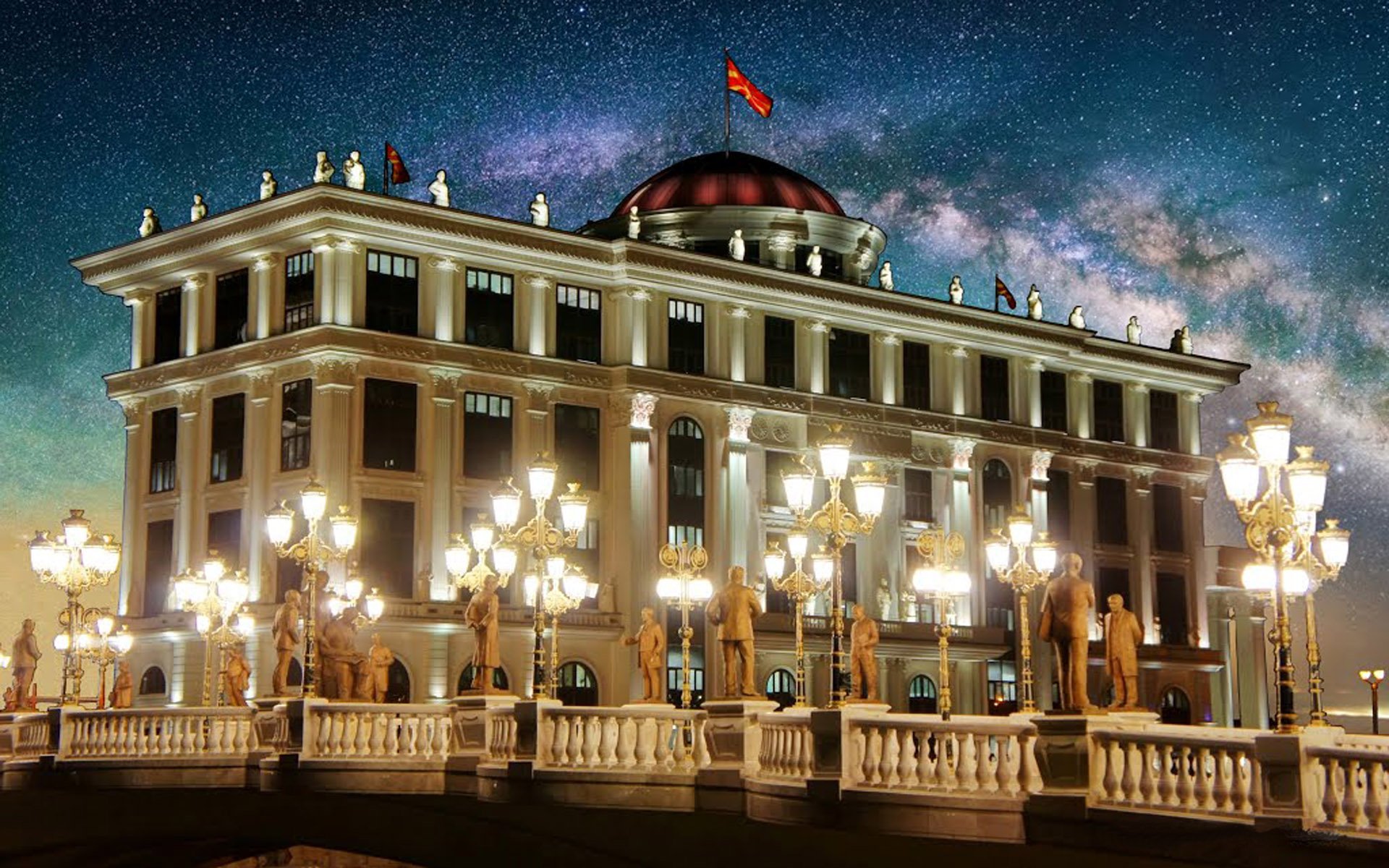 Baroque-style building in Skopje illuminated at night under a starry sky, showcasing intricate architectural details and grand lamp posts.