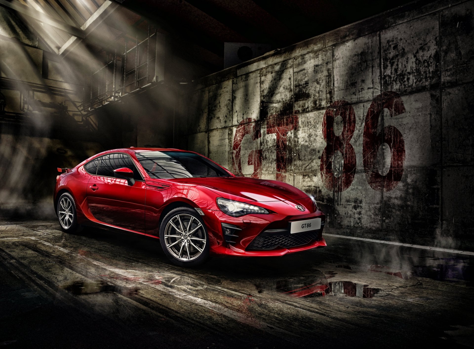 A red Toyota 86 sports car in a dimly lit, industrial setting, showcased in stunning 4K Ultra HD as a PC desktop wallpaper and background.