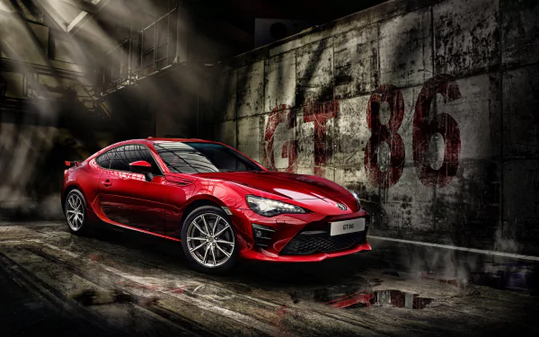 A red Toyota 86 sports car in a dimly lit, industrial setting, showcased in stunning 4K Ultra HD as a PC desktop wallpaper and background.