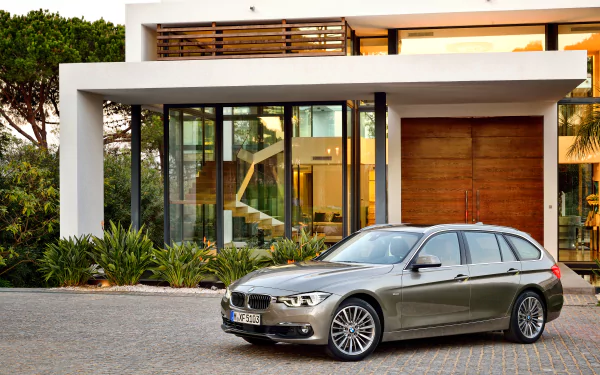 Silver BMW 3 Series parked in front of a modern house, captured in a sharp 4K Ultra HD desktop wallpaper image.
