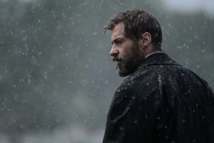 HD wallpaper featuring Hugh Jackman as Wolverine in the movie Logan, portraying a brooding figure amidst a snowfall backdrop.