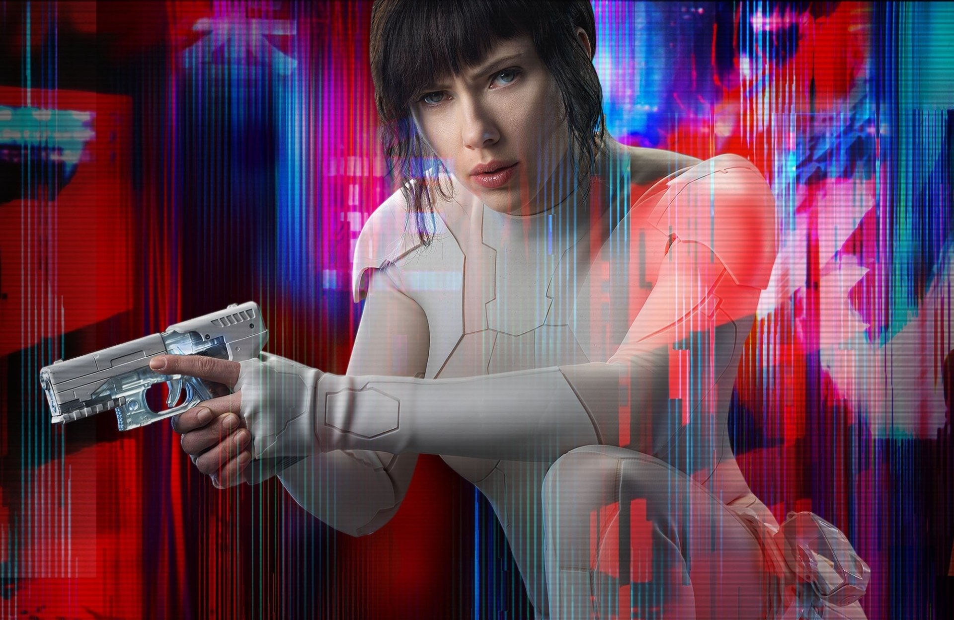 Scarlett Johansson in a futuristic suit, pointing a gun, amidst a vivid, neon background from the movie Ghost in the Shell (2017). This HD image serves as a striking desktop wallpaper and background.