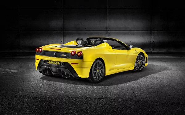 Yellow Ferrari Scuderia Spider 16M sports car showcased against a dark industrial background, featured as an HD PC desktop wallpaper and background.