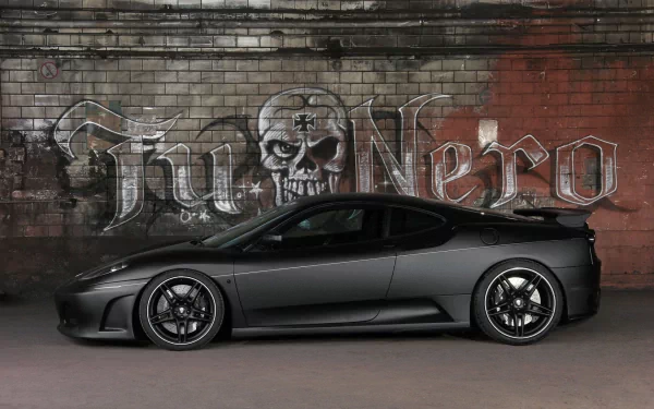 HD wallpaper of a sleek, black Ferrari parked in front of a gritty, graffiti-covered brick wall. The artwork on the wall includes a skull and the words Fu Nero.