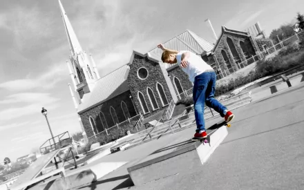 A skateboarder performs a trick on a concrete ledge, with a striking church in the background. This dynamic image captures the essence of skateboarding sports in a bold, high-definition style.
