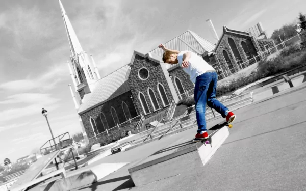 A skateboarder performs a trick on a concrete ledge, with a striking church in the background. This dynamic image captures the essence of skateboarding sports in a bold, high-definition style.