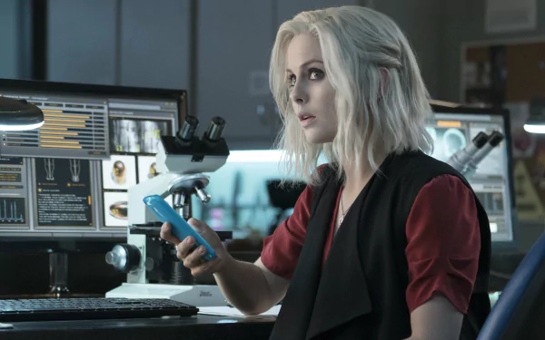 Blonde woman in a lab holding a phone, computer monitors and a microscope behind her — iZombie TV show 2K Quad HD PC wallpaper
