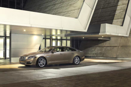 Silver Jaguar XJ parked in front of a modern architectural building, captured in a sharp 4K Ultra HD desktop wallpaper image.
