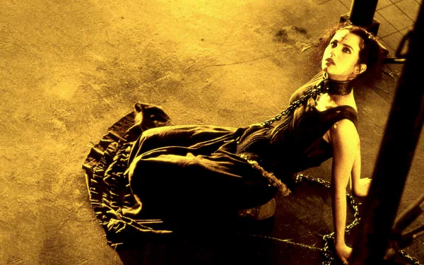 HD PC desktop wallpaper of a gothic woman in a dark dress chained to a post under dramatic yellow lighting, evocative of the film The Crow: City of Angels.