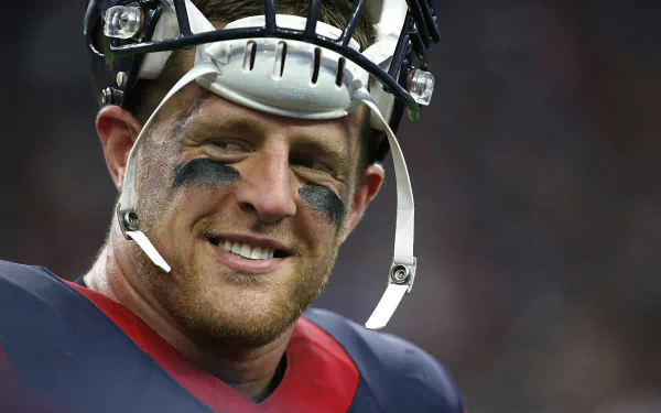 HD PC desktop wallpaper featuring J.J. Watt in sports gear, smiling with a football helmet and eye black during a game.