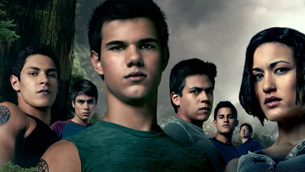 A group of characters from The Twilight Saga: Eclipse, featuring Jacob Black portrayed by Taylor Lautner, set against a dark, forested backdrop.
