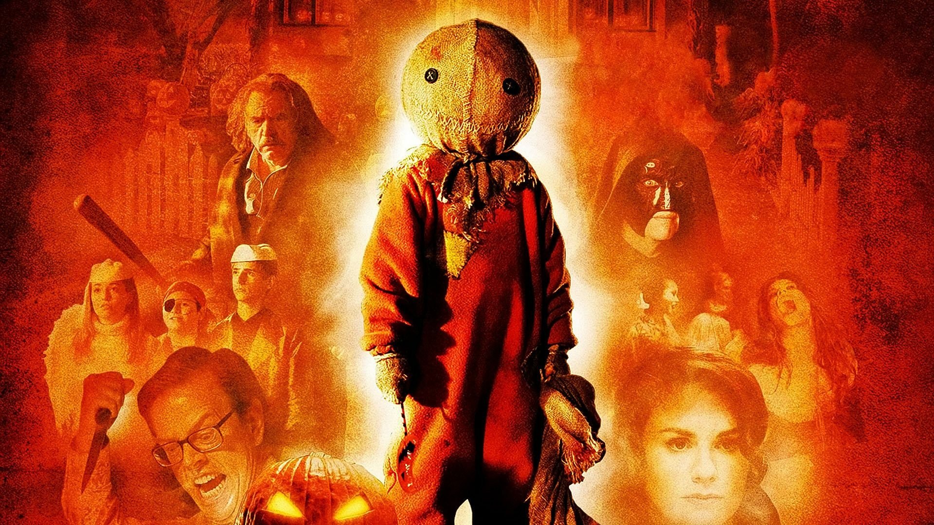HD PC desktop wallpaper/background of Trick 'r Treat: burlap‑masked Sam in an orange jumpsuit centered against a fiery backdrop of other movie characters.