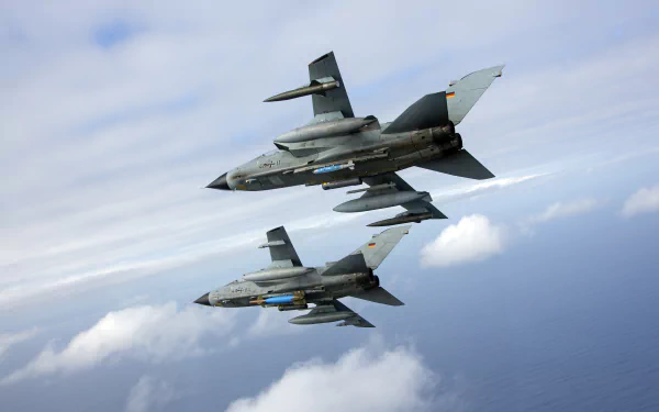 Two Panavia Tornado jet fighter warplanes fly in formation above the clouds, displayed in vibrant 4K Ultra HD quality as a military aircraft desktop wallpaper.