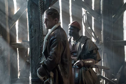 A HD desktop wallpaper from King Arthur: Legend of the Sword featuring Djimon Hounsou and Charlie Hunnam in a dramatic scene.