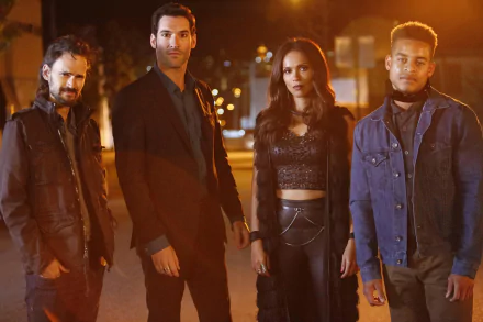 HD wallpaper featuring Robert Ri'chard, Jeremy Davies, Lesley-Ann Brandt, and Tom Ellis from the TV show Lucifer. The cast is standing outdoors together at night, with a cityscape blurred in the background.
