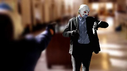 A high-definition wallpaper featuring the Joker from *The Dark Knight*, wearing a clown mask and suit, holding a Glock with an intense background scene.