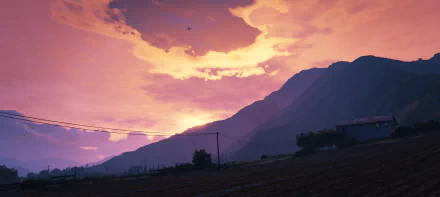 Grand Theft Auto V 2K Quad HD PC desktop wallpaper: glowing orange-pink sunset over silhouetted mountains, fields and distant power lines.